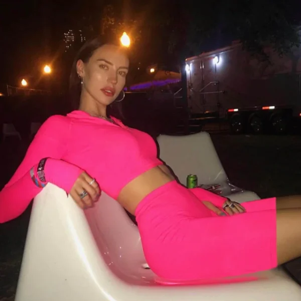 A woman in pink outfit sitting on chair.