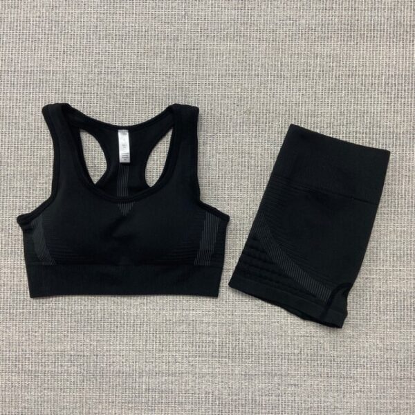 A black sports bra and shorts set on the floor.