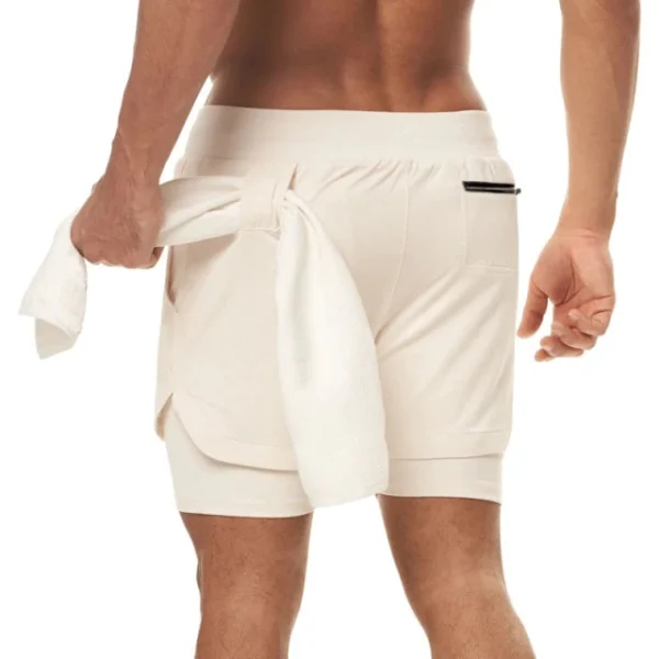 A man in white shorts holding onto a towel.