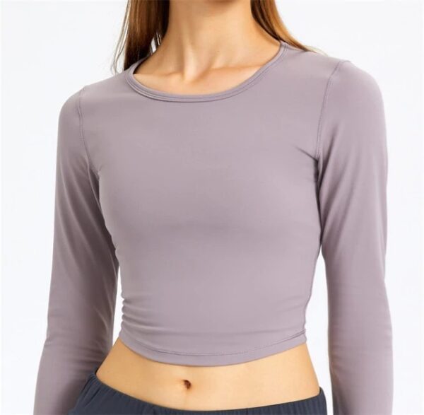 A woman wearing a long sleeve top with a small waist.