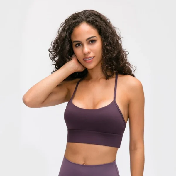 A woman wearing a purple sports bra and leggings.