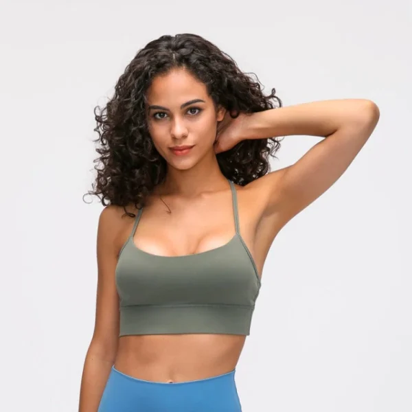 A woman in a green sports bra and blue pants.