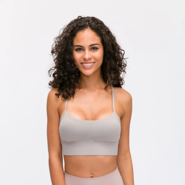 A woman with curly hair wearing a bra and leggings.