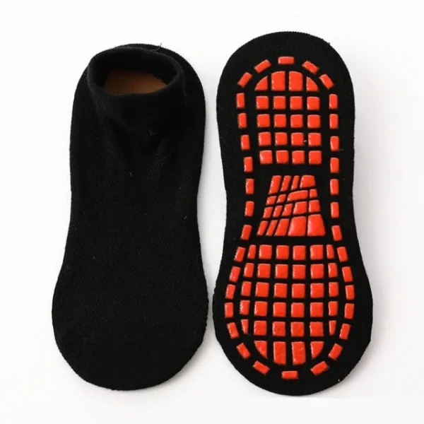 A pair of black socks with an orange sole.