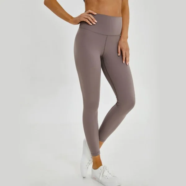 A woman is standing in her yoga pants