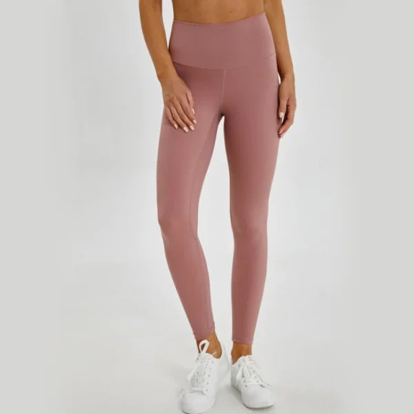 A woman wearing pink leggings and white sneakers.