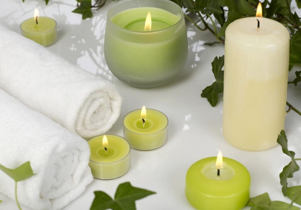 A group of candles and towels on the floor.